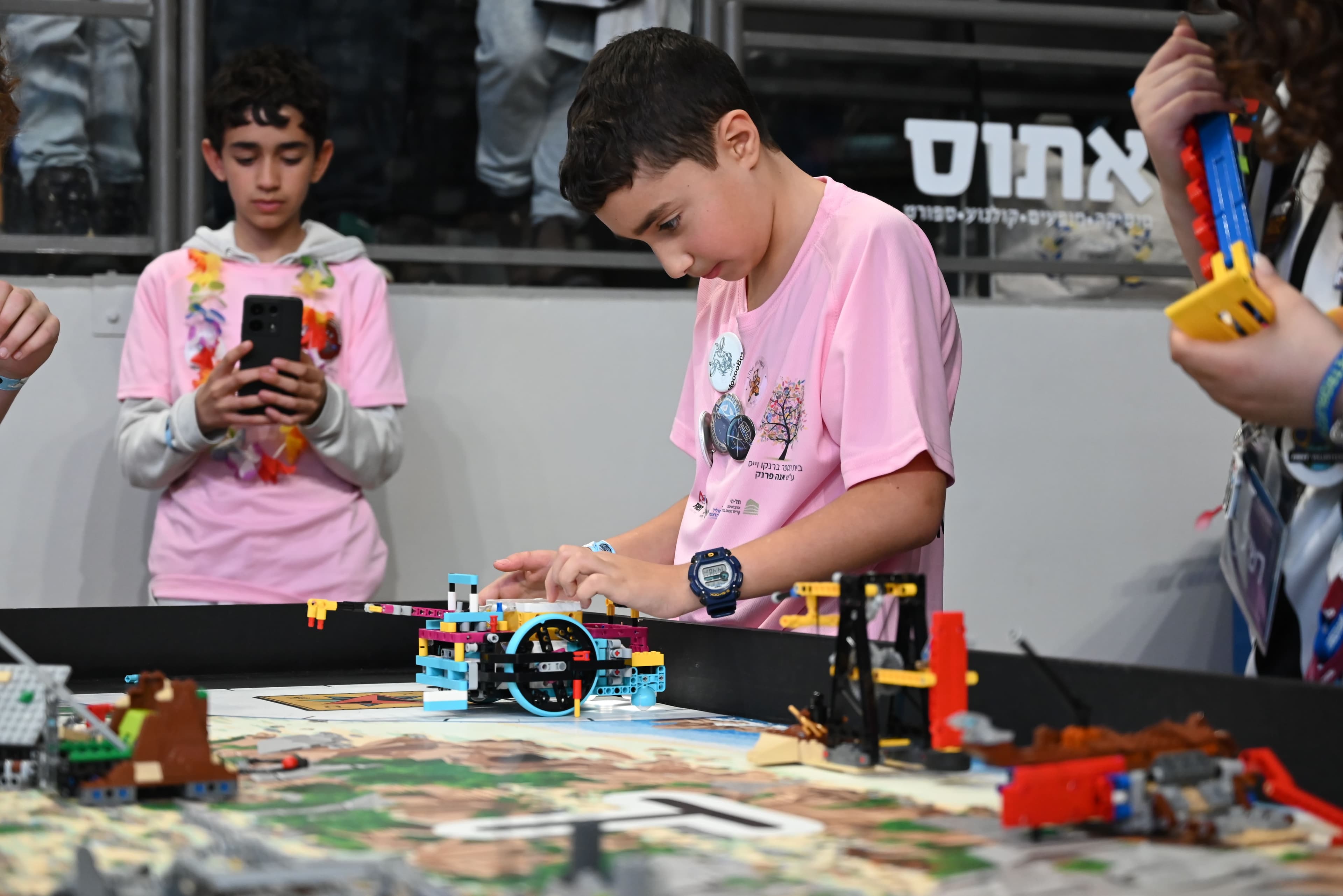 תלמיד צעיר מפעיל רובוט מ-LEGO בתחרות.