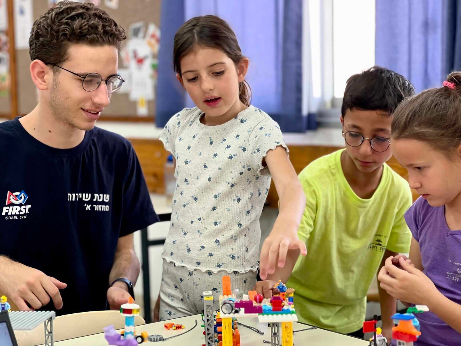 תלמידות צעירות מפעילות רובוט בתחרות