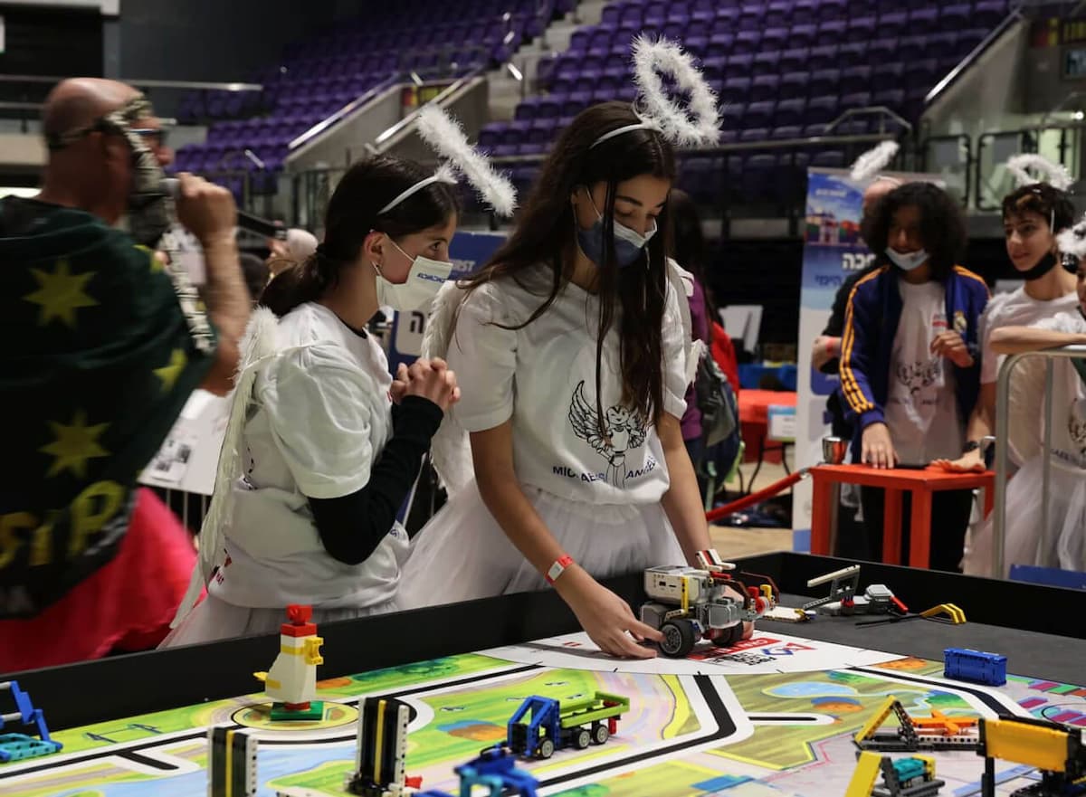 תלמידות צעירות מפעילות רובוט בתחרות