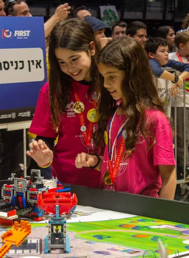 2 תלמידות צעירות מריצות רובוט LEGO בתחרות